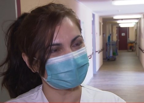 Junge Dame mit Maske wird von einem Kamerateam interviewt