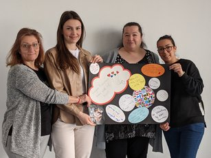 Teilnehmende an der HWA-Aktion „Für Demokratie und gegen Ausgrenzung“ halten selbstgebasteltes Plakat gegen Rassismus