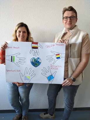 Teilnehmende an der HWA-Aktion „Für Demokratie und gegen Ausgrenzung“ halten selbstgebasteltes Plakat gegen Rassismus