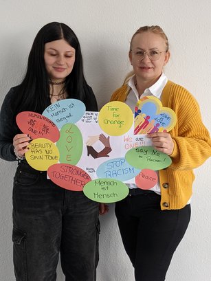 Teilnehmende an der HWA-Aktion „Für Demokratie und gegen Ausgrenzung“ halten selbstgebasteltes Plakat gegen Rassismus