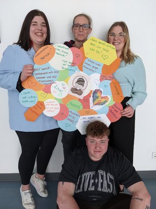 Teilnehmende an der HWA-Aktion „Für Demokratie und gegen Ausgrenzung“ halten selbstgebasteltes Plakat gegen Rassismus