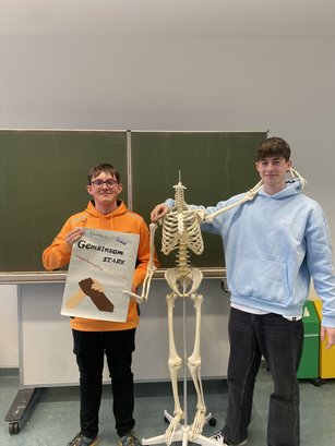 Teilnehmende an der HWA-Aktion „Für Demokratie und gegen Ausgrenzung“ halten selbstgebasteltes Plakat gegen Rassismus