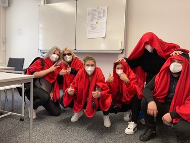 Schüler mit roten Decken auf dem Boden des Klassenzimmers