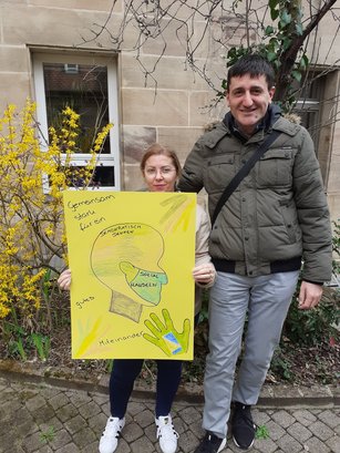 Teilnehmende der HWA-Aktion „Für Demokratie und gegen Ausgrenzung“ halten ein selbstgestaltetes Plakat gegen Rassismus