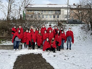 Klassenfoto mit roten Decken im Schnee